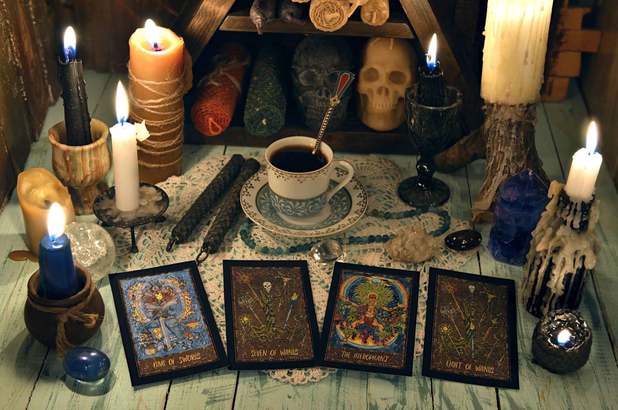 Cards arranged on a table beside candles